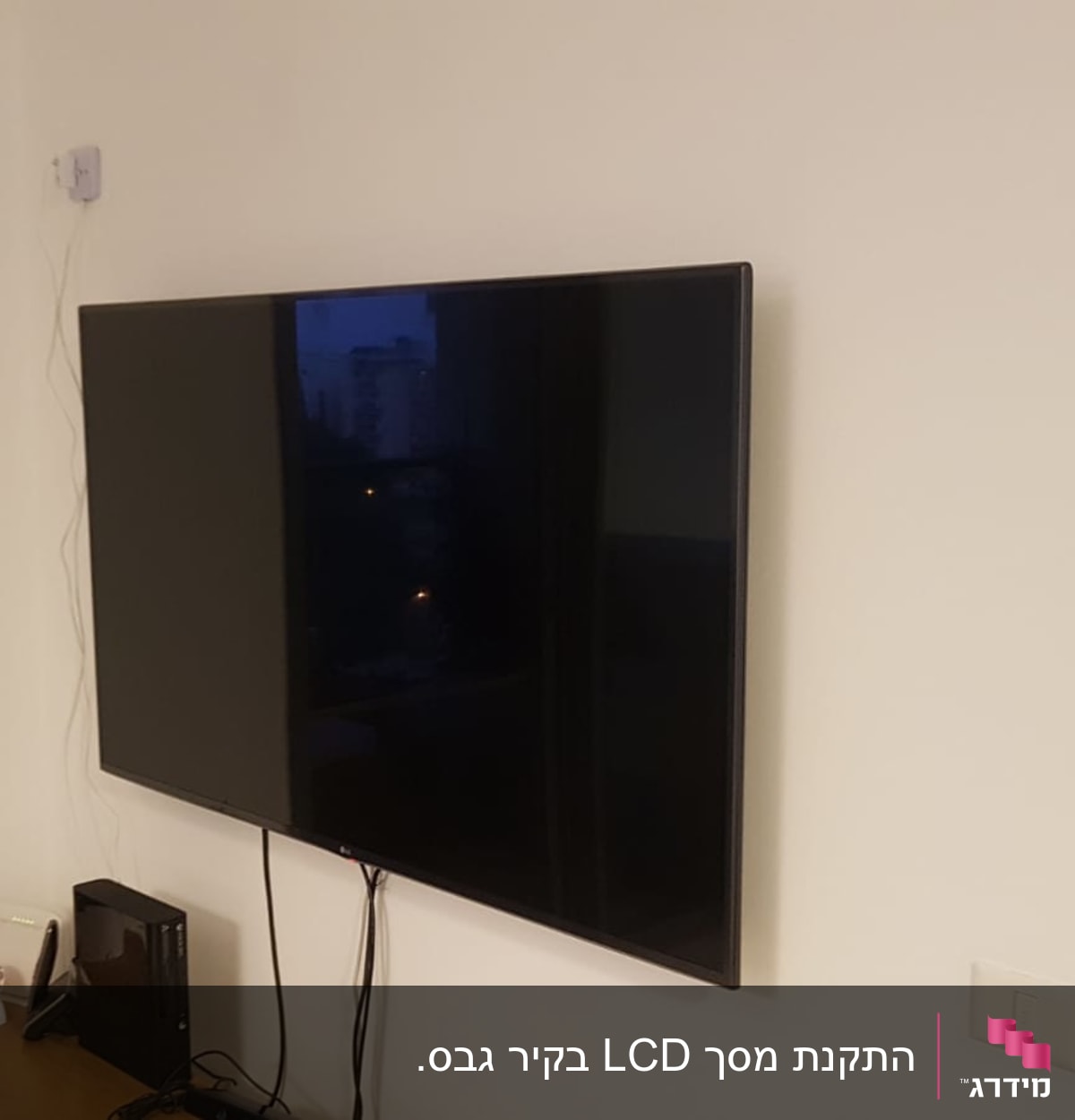 טלוויזיה תלויה על הקיר עם כבלים מחוברים